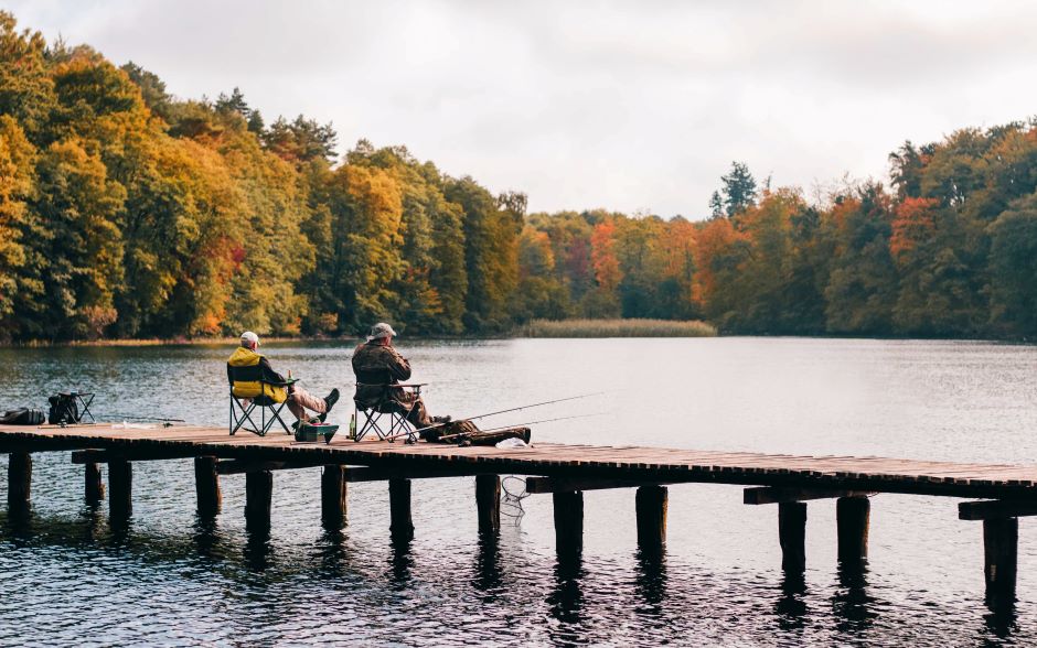 two fisherman sitting on a dock, waiting for a catch (Environmental Impacts of Fishing)