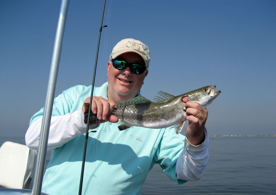 Fisherman holding a speckled trout